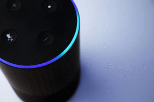 Close-up of an Alexa smart speaker with a glowing blue light ring.